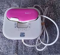 Top view of Silk'n SensEpil base unit with handpiece and attached internal cord