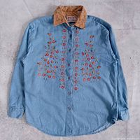 Full front view of embroidered denim shirt with corduroy collar