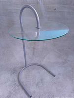 Full view of side table showing arched frame and glass top