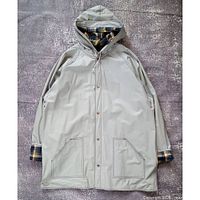 Full view of grey hooded raincoat front showing pockets, hood, plaid lining