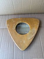 Front of triangular wooden block with central magnifying lens