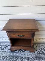 Front view showing drawer, open shelf, bracket feet