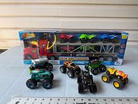 Overall lot showing boxed carrier playset and six loose monster trucks