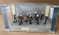 Full set of 11 figures in display case front view
