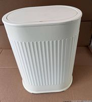Full view of closed oval trash can showing color, shape and ribbed sides
