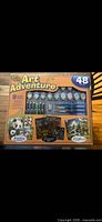 Front of boxed Art Adventure 48-piece paint-by-number kit showing brushes, paint pots and sample artworks