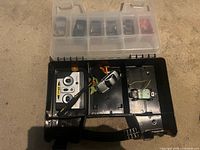 Open case showing controller, silver car, spare PCB and upper compartment with six cars