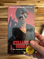 Front cover of sealed Cobra VHS sleeve with shrinkwrap and sticker