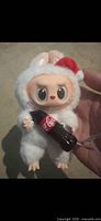 Front view showing bunny plush keychain, Santa hat, Coke bottle accessory