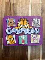 Front of purple Garfield tin with character graphics