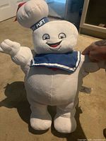 Front view of Stay Puft Marshmallow Man plush showing face, collar and size