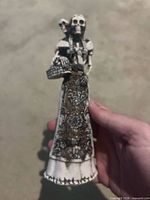 Front view of skeleton figurine showing dress pattern, basket and skull detail