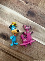 Front view of both figurines standing on wood surface