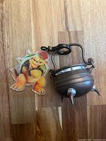 Cauldron keychain and Bowser insert side by side