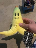 Front view of banana peel plush showing face and tag