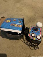 Joystick console beside damaged retail box