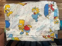 Folded Simpsons character cotton flat sheet, showing Homer, Maggie, Bart graphics