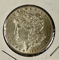 Obverse of 1889 Morgan silver dollar in cardboard coin holder