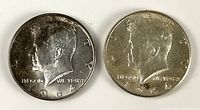 Obverse of both 1964 Kennedy half dollar coins, showing dates and mint marks