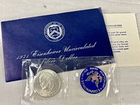Full set showing coin sealed in plastic, blue US Mint token, envelope, and info card