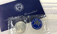 Front of sealed 1971-S Eisenhower dollar with blue token and envelope