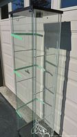 Full view of glass display cabinet showing shelves, door, black top and base