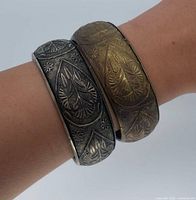 Both bangles worn stacked on wrist showing design and color contrast