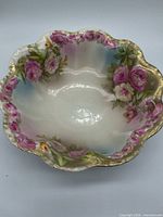 Top view showing scalloped rim, floral decoration, and gilt edge
