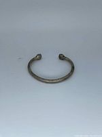Top view of entire torque cuff bracelet showing bulb ends and patina