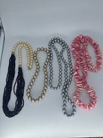All four necklaces laid flat showing styles and colors