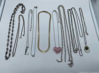 All nine necklaces laid out showing variety and pendants