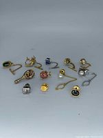 Group shot of 11 vintage tie tacks and chain fasteners