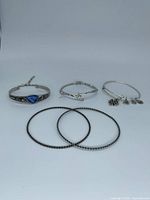 Group shot of all five silver-tone bracelets