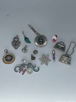 Group shot of all 14 assorted charms, pendants and tokens