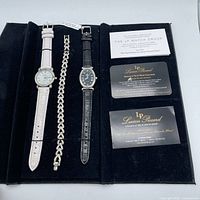 Gift set open showing two watches, bracelet, documentation