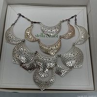 Necklace displayed in open box showing full bib design and chain