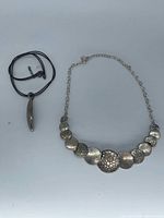 Both necklaces laid flat showing overall design and components