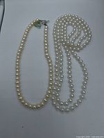 Two necklaces side by side showing length and bead color difference