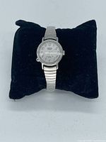 Full view of watch on cushion displaying band and dial