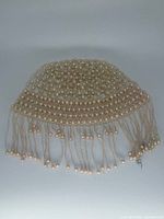 Top view of faux pearl lattice cap with fringe