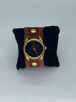 Front view of watch on pillow, showing case and strap