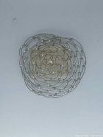 Front view showing spiral wire design, bead accents, central rhinestone
