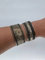 Cuff bracelets worn on wrist demonstrating width and finish