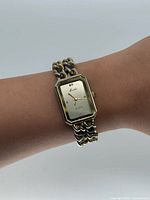 Front view of Moulin rectangular gold-tone watch on wrist