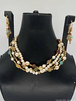 Necklace displayed on bust with matching earrings