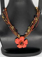 Full view of necklace on display bust showing strands and pendant