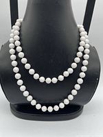 Necklace displayed doubled on bust form showing bead uniformity and drape