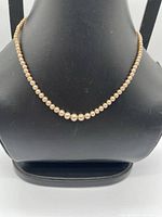 Full view of necklace on display bust showing graduated pearls