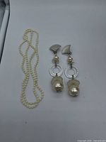 Necklace coiled beside earrings showing full lot