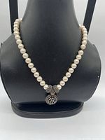 Full view of faux pearl necklace on bust showing pendant and strand